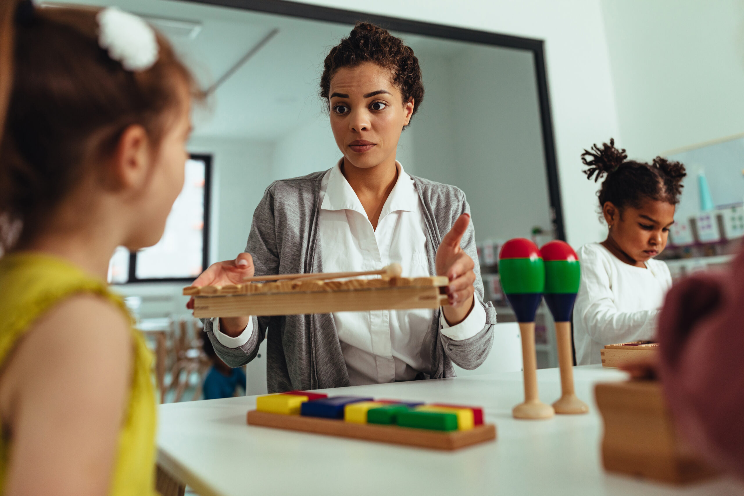 Teacher with children playing at kindergarten