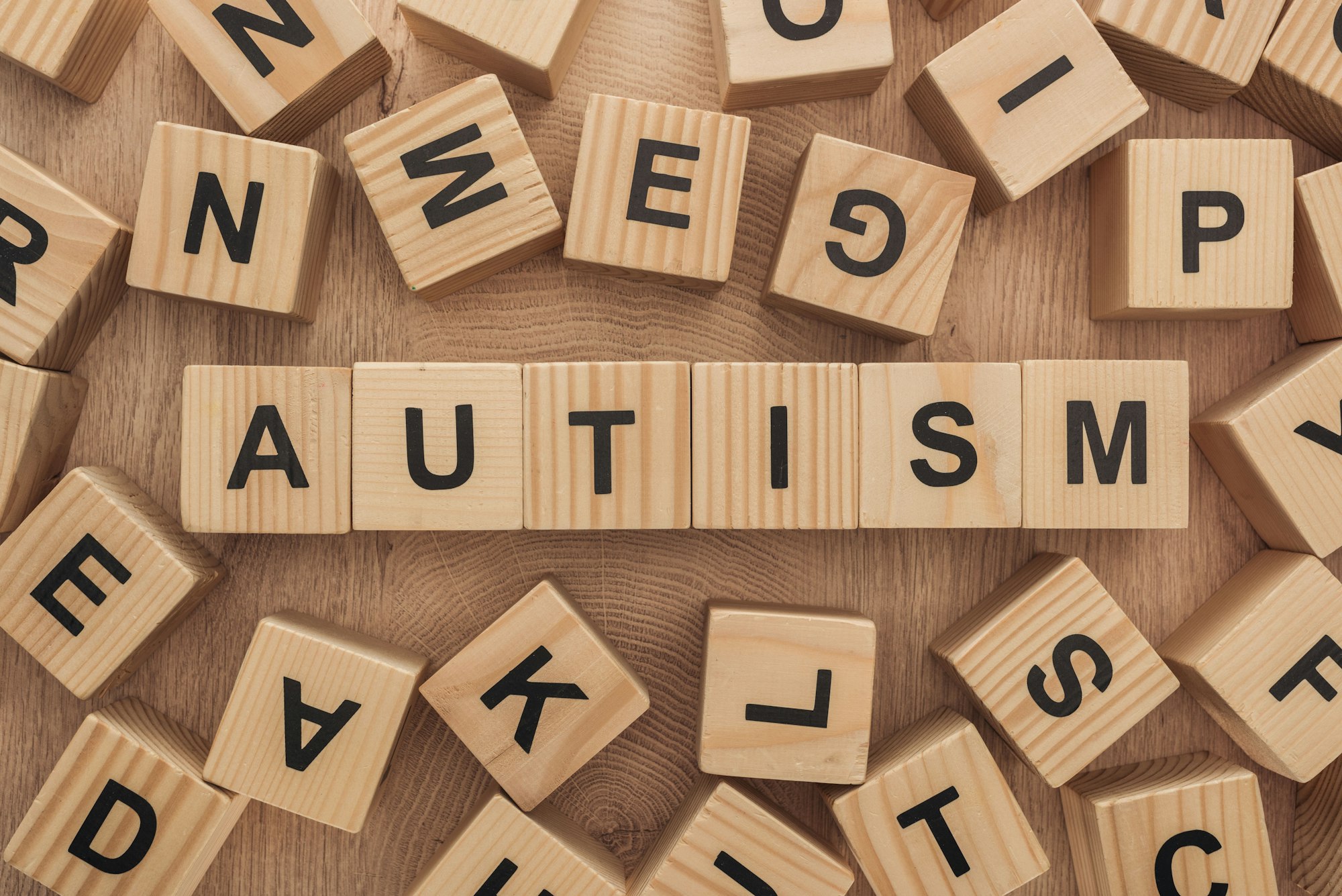 top view of autism lettering among wooden blocks with letters